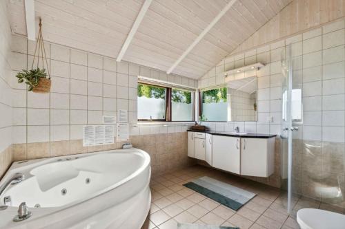 a bathroom with a tub and a sink and a toilet at Well-Equipped Summer House Near Skovmose in Neder Lysabild
