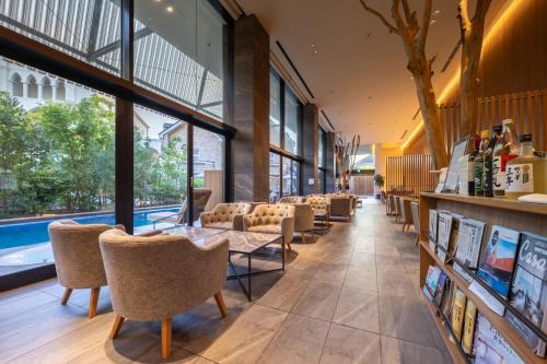 a lobby with chairs and a table and windows at Garden Terrace Fukuoka in Fukuoka