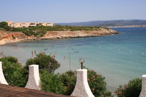 a view of a beach with people in the water at Hotel Punta Negra in Alghero