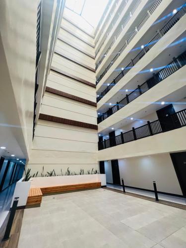 a lobby with a staircase in a building at Victorian Suites at Brenthill Baguio City Center in Tuding
