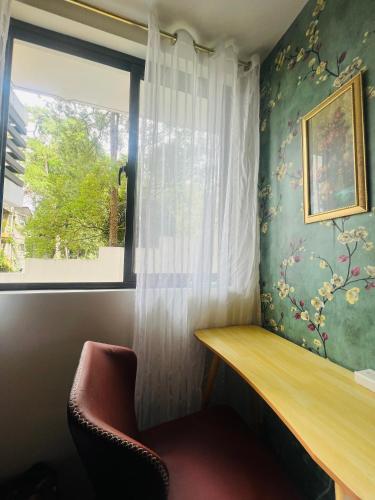 a room with a window and a desk and a chair at Victorian Suites at Brenthill Baguio City Center in Tuding