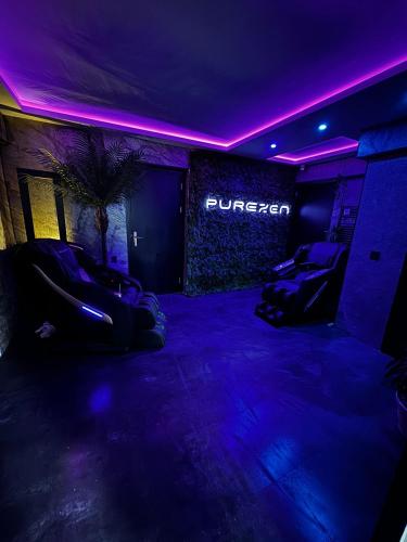 a dark room with purple lights and a burger sign at Spartementen by Pure-Zen in Rotterdam