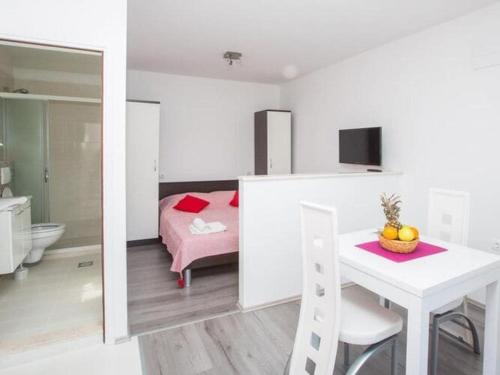 a room with a bed and a table and a bathroom at Villa Roza - Studio Apartment with Balcony in Mokošica