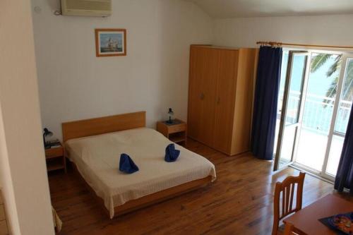 a bedroom with a bed with blue pillows on it at Apartments Lozica - Standard Studio Apartment with Terrace and Sea View in Dubrovnik