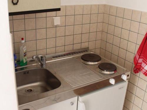 a small kitchen with a sink and a stove at Apartments Lozica - Standard Studio Apartment with Terrace and Sea View in Dubrovnik