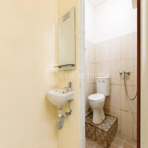 a bathroom with a toilet and a sink at Pulogadung Residence by Nam RedPartner in Jakarta
