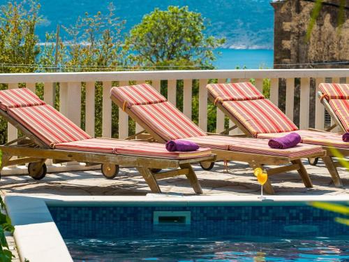 two deck chairs with pillows sitting next to a pool at Villa Mia -Three-Bedroom Villa with Swimming Pool in Trsteno