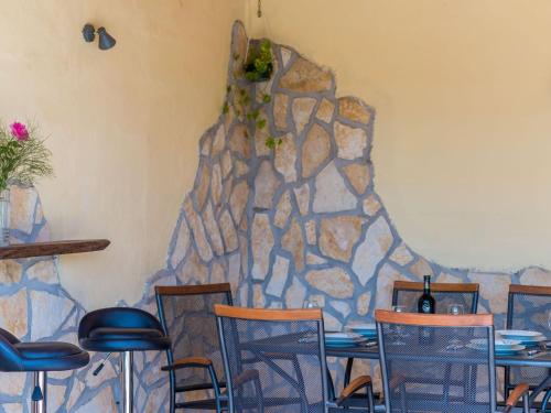 a room with tables and chairs and a stone wall at Villa Dalmatian Gem - Two-Bedroom Villa with Terrace and Swimming Pool in Gruda