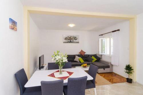 a living room with a table and a couch at Villa Dalmatian Gem - Two-Bedroom Villa with Terrace and Swimming Pool in Gruda