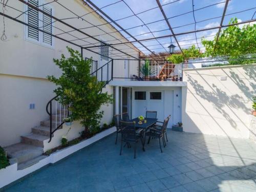 a patio with a table and chairs in a house at Villa Dalmatian Gem - Two-Bedroom Villa with Terrace and Swimming Pool in Gruda