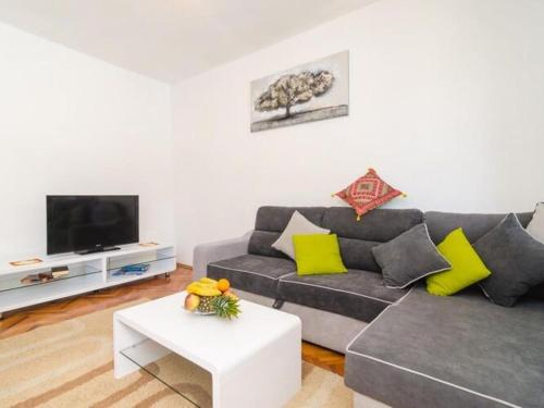 a living room with a couch and a tv at Villa Dalmatian Gem - Two-Bedroom Villa with Terrace and Swimming Pool in Gruda