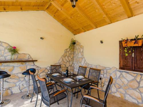 a table and chairs in a room with a stone wall at Villa Dalmatian Gem - Two-Bedroom Villa with Terrace and Swimming Pool in Gruda