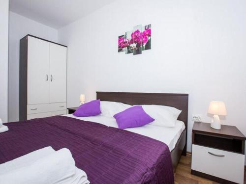 1 Schlafzimmer mit 2 Betten mit lila und weißen Kissen in der Unterkunft Villa Roza - One-Bedroom Apartment with Balcony in Mokošica
