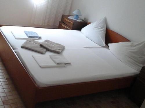 Una cama con sábanas blancas y toallas. en Apartments and Room Katja - Two Bedroom Apartment with Terrace, en Mlini