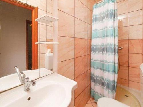 a bathroom with a sink and a toilet and a mirror at Apartment Stipic Omis - Three Bedroom Apartment with Terrace in Omiš