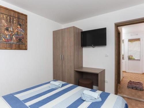 ein Schlafzimmer mit einem Bett und einem Flachbildfernseher in der Unterkunft Apartments Stipo - One Bedroom Apartment with Terrace and Sea View A4 in Drače