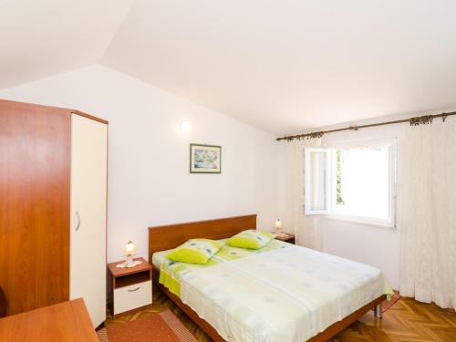 ein Schlafzimmer mit einem Bett und einem Fenster in der Unterkunft Holiday Home Jasenka Trstenik - Duplex One Bedroom Apartment with Terrace and Side Sea View in Trstenik