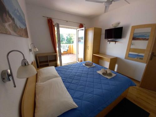 a bedroom with a blue bed with a pair of shoes on it at One-bedroom apartment with terrace in Sobra