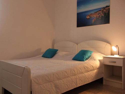 a bedroom with a white bed with two blue pillows at Villa Nika-Five Bedroom Villa with Pool in Mlini