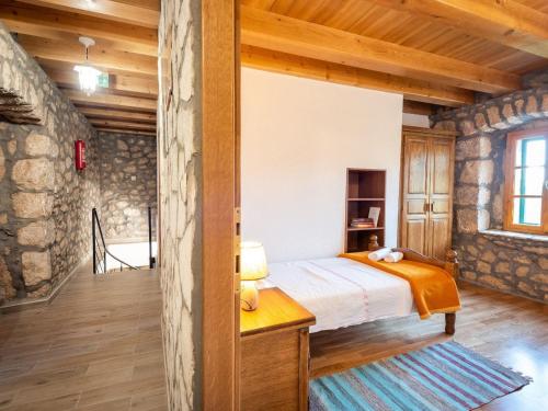 ein Schlafzimmer mit einem Bett und einer Steinwand in der Unterkunft Villa Lazini Dvori - Two Bedroom Stone House Villa with Private Pool in Staševica