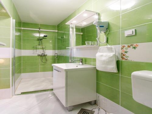 ein grünes Bad mit einem Waschbecken und einer Dusche in der Unterkunft Villa Balarin - Five Bedroom Holiday Home with Terrace and City View in Bol