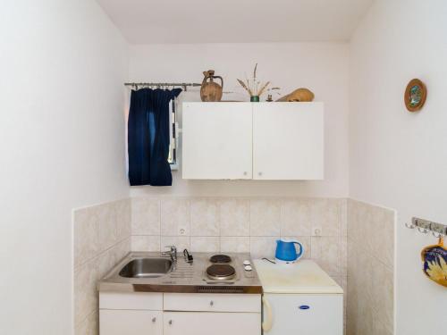 a kitchen with white cabinets and a sink at Apartments Ra ica Molunat - Basic Studio in Molunat