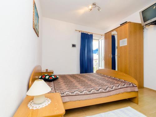 a bedroom with a bed and a table with a lamp at Apartments Ra ica Molunat - Basic Studio in Molunat