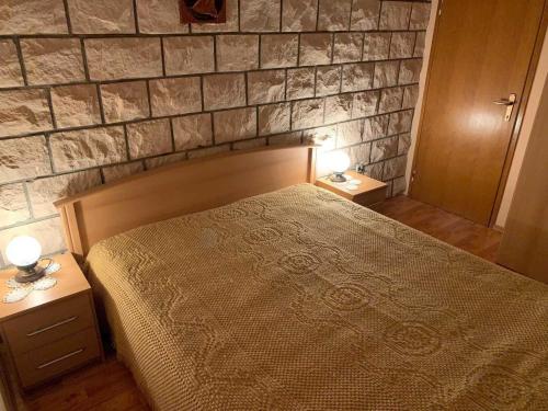 a bedroom with a bed and two night stands with lamps at Apartments Nives - Three Bedroom Apartment with Terrace and Sea View in Smokvica