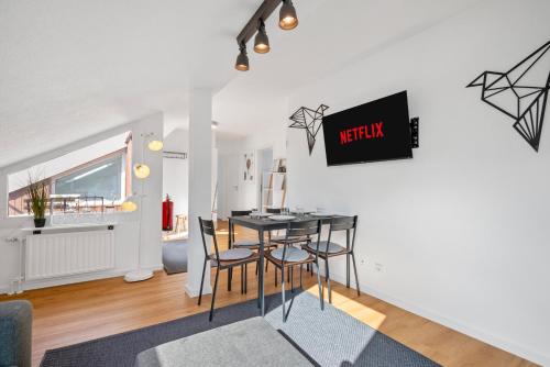 a dining room and living room with a table and chairs at BackHome - BUSINESS&FAMILY - Parken, 3-Zimmer, SmartTV, Balkon, Waschmaschine, ruhige Stadtrand-Lage, Netflix, 60qm, 24h Checkin in Ludwigsburg
