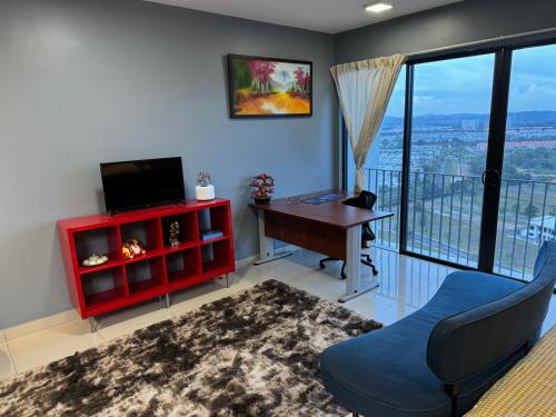 a living room with a red cabinet and a desk with a television at Sermenta Studio Trefoil in Setia Alam