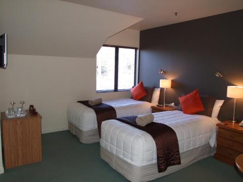 a hotel room with two beds and two lamps at Drifters Inn in Hanmer Springs