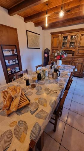 - une table à manger avec une longue table et des chaises dans l'établissement Les Chambres du Saladou, à Mont-Chanson