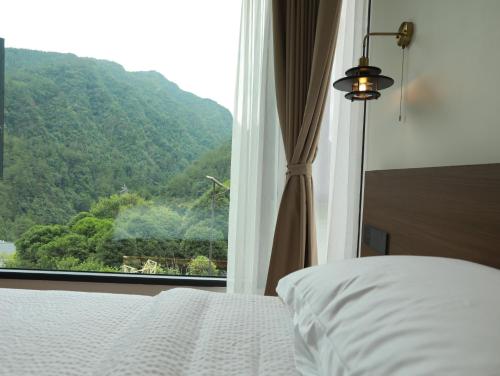 a bedroom with a bed and a large window at 张家界喜屋民宿 in Zhangjiajie