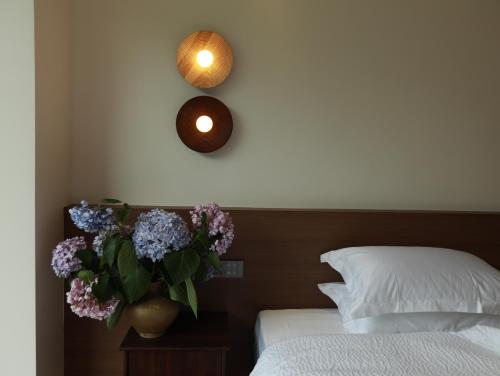 a bedroom with a bed and a vase of flowers on a table at 张家界喜屋民宿 in Zhangjiajie