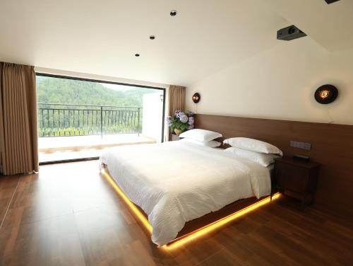 a bedroom with a large bed with a large window at 张家界喜屋民宿 in Zhangjiajie