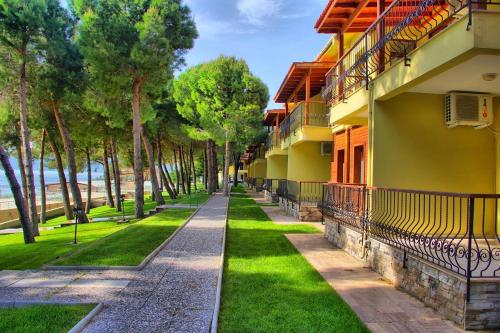 a walkway in front of a building with grass and trees at Dardanos Yerleşkesi in Hamidiye
