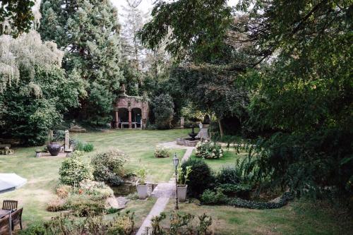 a garden with benches and flowers in the grass at Hotel Altes Rittergut in Sehnde