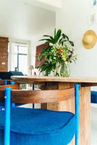 a dining room table with a vase of flowers on it at Ndani House in Arusha