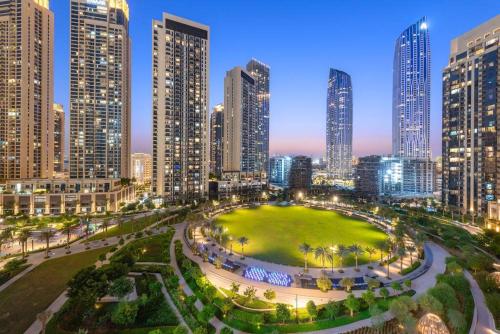 a city skyline at night with a large park at FIRST CLASS 2BR Stylish Bliss in Dubai