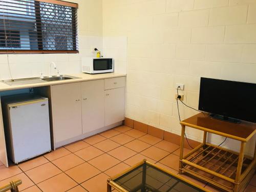 a kitchen with a sink and a microwave at Koala Beach Resort Cairns in Cairns
