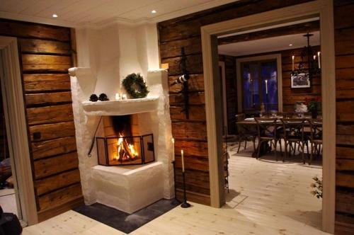 a living room with a fireplace and a dining room with a table at Vemdalsskalets Högfjällshotell & lägenheter in Vemdalsskalet