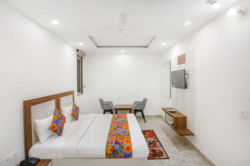 a bedroom with a bed and a table and chairs at FabHotel Aerosky - Nr Yashobhoomi Convention Centre in New Delhi