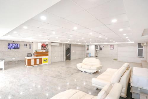 a waiting room with white chairs and a table at FabHotel Aerosky - Nr Yashobhoomi Convention Centre in New Delhi