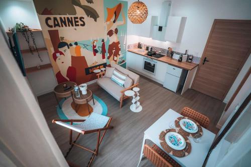 un salon avec un canapé et une table et une cuisine dans l'établissement Le Bord de Mer - Votre Séjour Vitaminé & Cozy, à Châteauroux