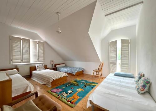 a attic bedroom with two beds and a rug at Dom Nadmorski "Casa Azul" Gdynia Kosakowo in Mechelinki