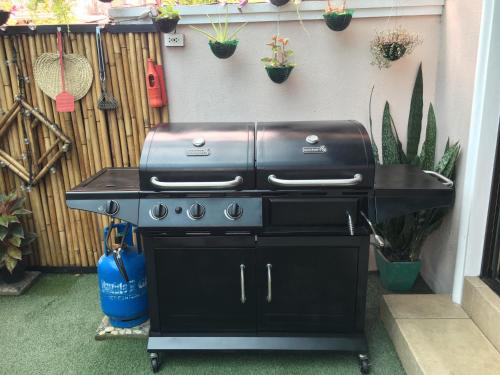 a grill on a cart in a backyard with potted plants at Eagle Ridge Family Vacation House in General Trias