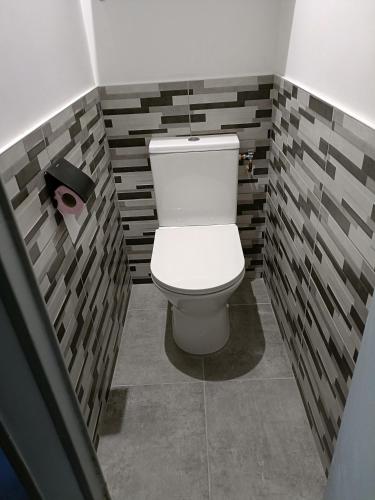 - une salle de bains avec toilettes dans une chambre aux murs de briques dans l'établissement studio cabine piscine au couchant, à La Grande Motte