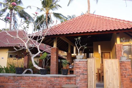 a brick house with a red roof at Petit Boo Amed in Amed