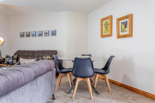 a living room with a couch and three chairs at Hunters Glebe Country Apartment in Castlerock