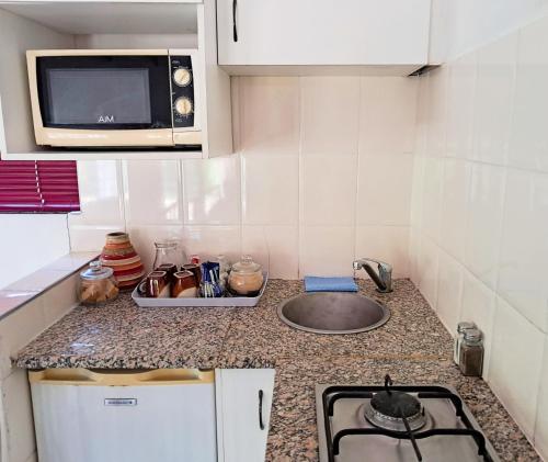 a kitchen counter with a sink and a microwave at 122 on Krantzview previously BizAfrika Guest Lodge in Kloof